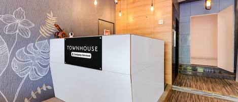 A reception desk with a sign reading 'TOWNHOUSE Company Serviced.'