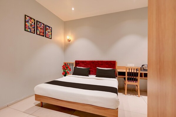 Ein Schlafzimmer mit Bett, Schreibtisch und Stuhl.