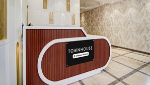 A reception desk with a sign reading 'TOWNHOUSE Company Serviced.' - Deluxe With Twin Bed Hotel Unistar (New Delhi)