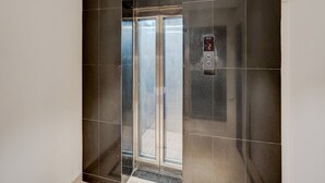 An elevator with a digital display showing the number 2, surrounded by dark tiles. - Deluxe With Twin Bed Hotel Unistar (New Delhi)