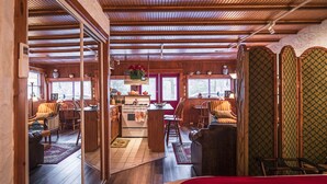 Un intérieur de chalet chaleureux avec des poutres en bois, un coin cuisine et un espace repas.