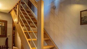 A wooden staircase with a handrail, leading to an upper floor. - Chez Ludo I T4 I Francin (Porte-de-Savoie)