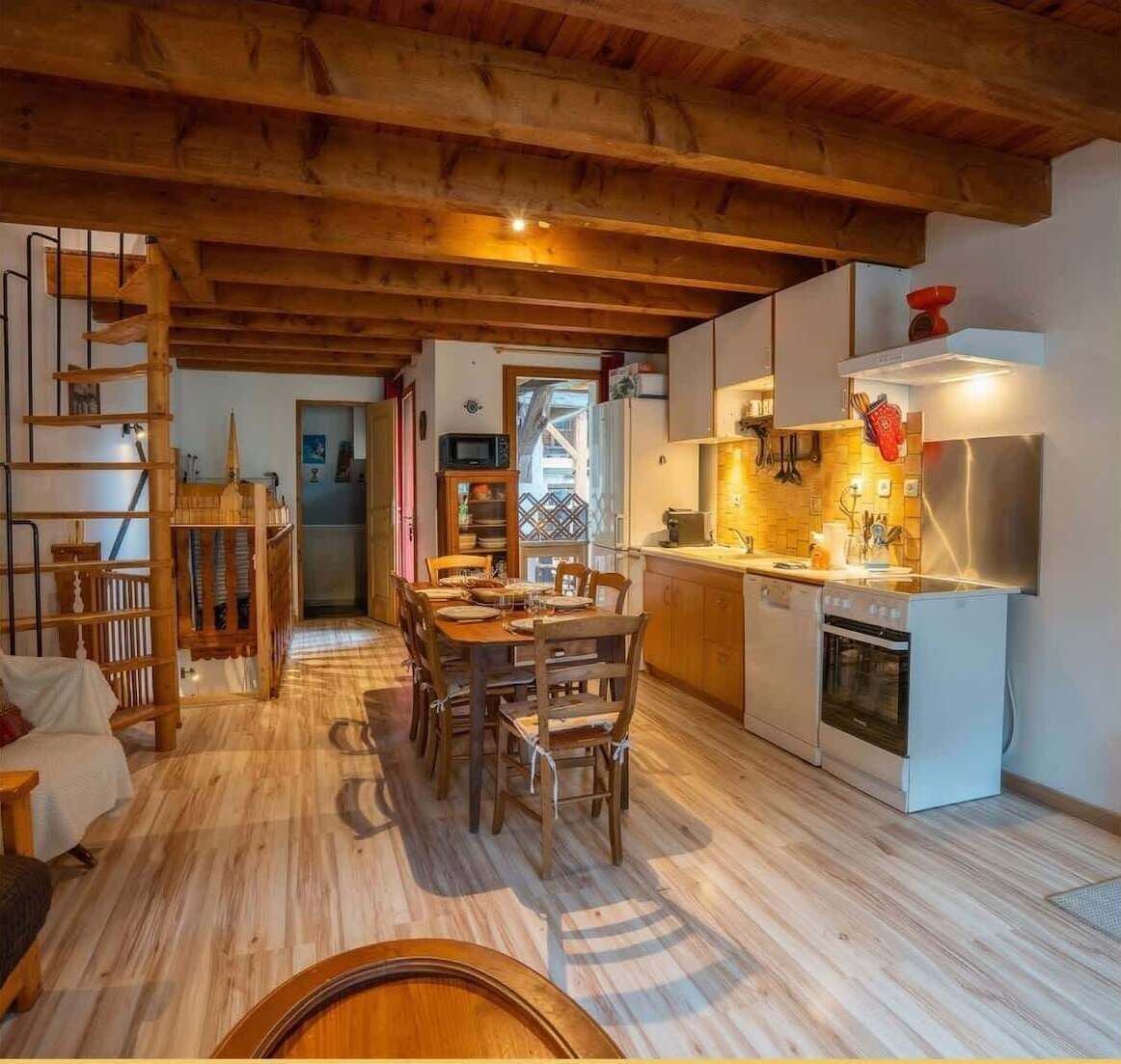 Interior de madeira com sala de jantar, cozinha e escada.
