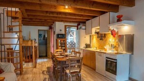 A wooden interior with a dining area, kitchen, and staircase. - Chez Ludo I T4 I Francin (Porte-de-Savoie)