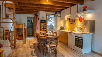 Interior de madeira com sala de jantar, cozinha e escada.