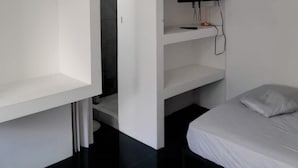 A modern room with a bed, a TV mounted on a wall, and a walk-in closet. - Costa Rica Walk In (San José)