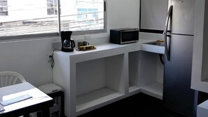 A modern kitchen with a built-in microwave, a refrigerator, and a ceiling fan. - Costa Rica Walk In (San José)