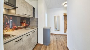Una cocina moderna con encimera de madera, horno empotrado y espejo montado en la pared.