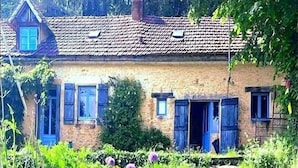 A rustic stone house with a tiled roof, blue shutters, and a garden with various wildflowers. - THE FARM: 145m2, 6 pers-3 bedrooms swimming pool/river/isolated/ Montignac Lascaux at 9.2km (Saint-Léon-sur-Vézère)