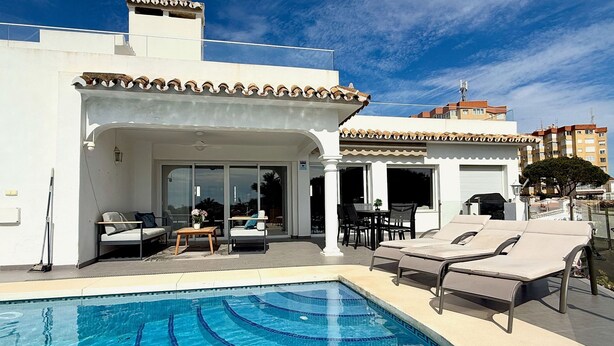 A poolside area with lounge chairs, a dining table, and a covered seating area. - Villa Ibiza by Solrentspain - La Cala de Mijas (Mijas Costa)
