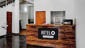 Ein Hotelrezeptionstisch mit einem Schild, das anzeigt, dass der Service durch die Firma übernommen wird.