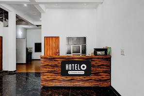 A hotel reception desk with a sign indicating it's company-serviced. - Hotel O Naroli Crossway Mathura (Mathura)