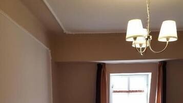 Une chambre à coucher avec un lit, une table de chevet, une lampe et une fenêtre avec des rideaux.
