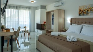 Une chambre d’hôtel comprenant un lit, un bureau, une chaise, une télévision, une armoire et un tableau au mur.