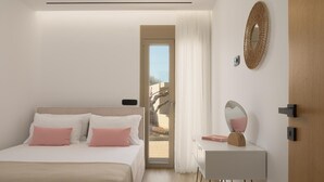 Una camera da letto con un letto, un comodino, uno specchio e una porta che dà su un balcone.