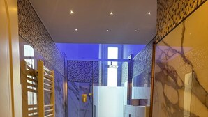 A modern bathroom with a glass shower enclosure, a freestanding bathtub, a marble-tiled floor, and a marble wall. - Impero Vaticano Ottaviano Apartment  (Rome)