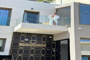 A modern building with a balcony, a sign reading 'SORORES luxury seaside living,' and a geometric pattern on the facade. - Beachside Villa with Pool in Agia Pelagia (Agia Pelagia)