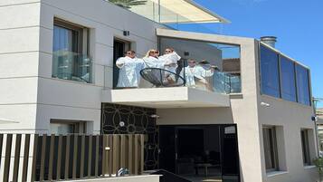 Ein modernes Gebäude mit Balkon, großen Fenstern und einer geometrischen Fassade.