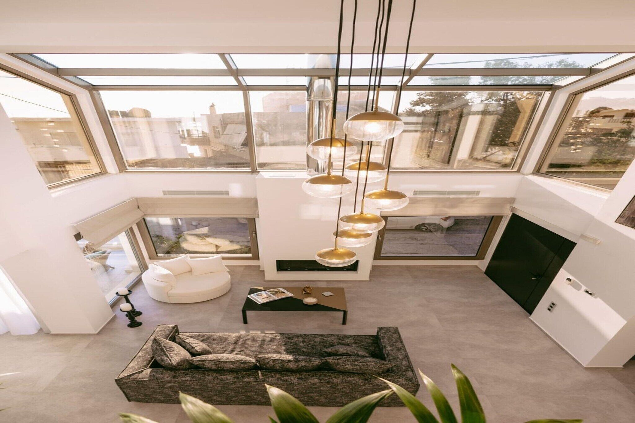 A modern interior with a skylight, a sofa, a coffee table, and a pendant light.