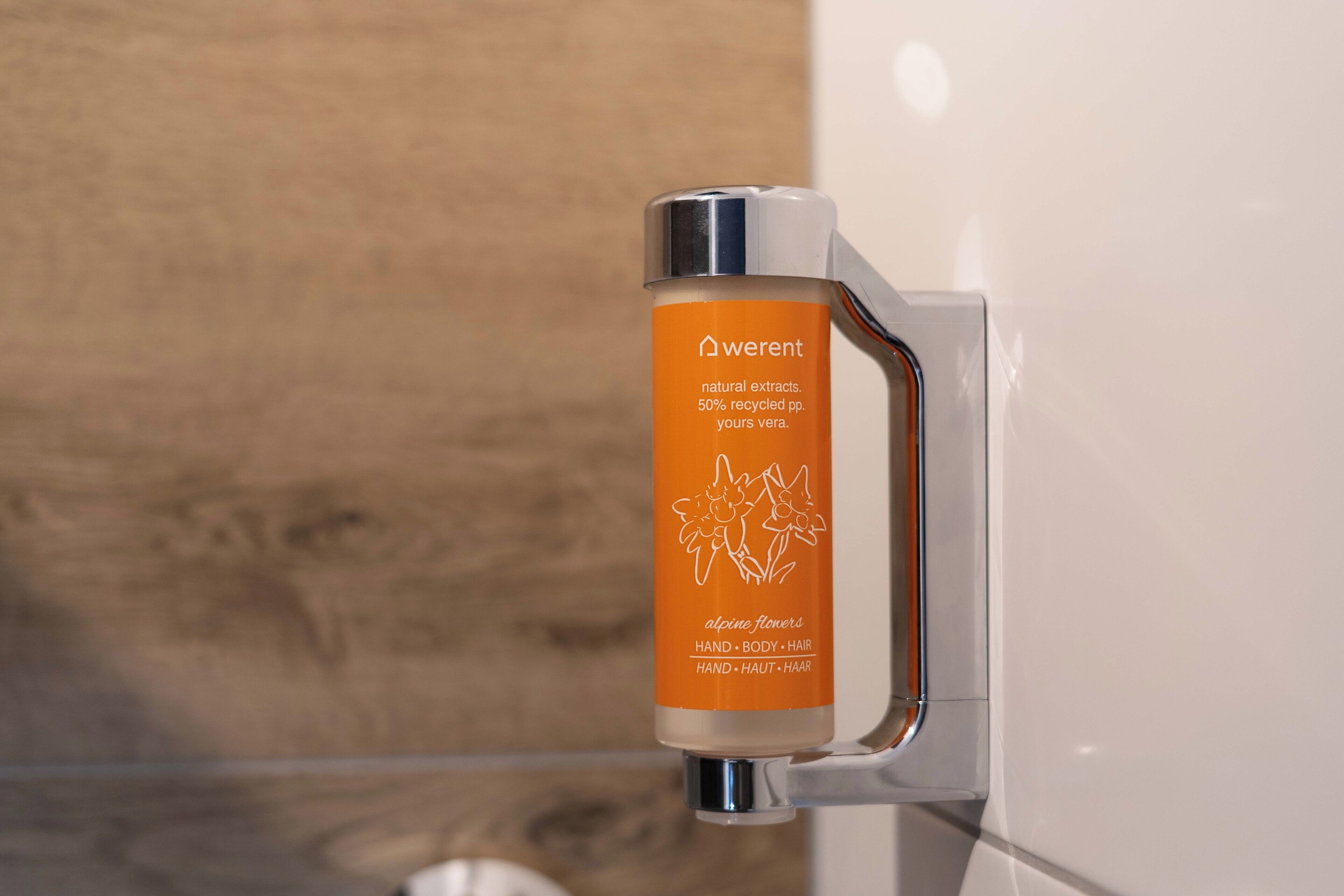 A bottle of Weren't natural extracts, 50% recycled paper, and your vera, with alpine flowers, for hand, body, and hair.