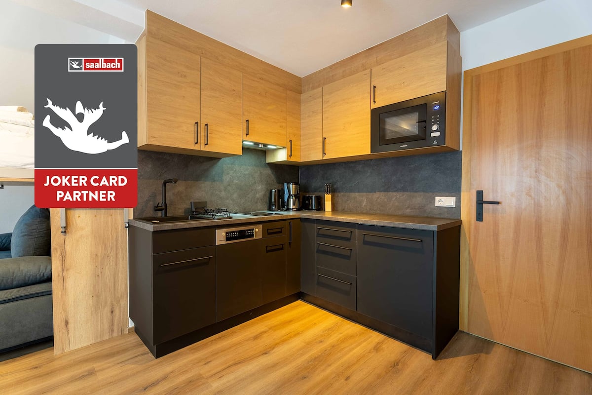 A modern kitchen with wooden cabinets, a built-in microwave, and a dishwasher.