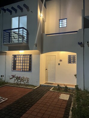 Ein zweistöckiges Gebäude mit Balkon, einem vergitterten Fenster und einer Tür mit der Nummer 24.
