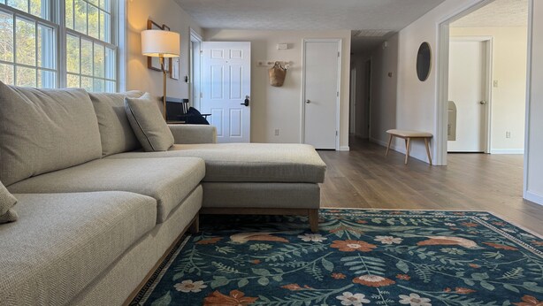 A living room with a sectional sofa, a ceiling fan, and a floral rug. - 3-bedroom House, Private Lake Access and Game Room (Hillsboro)