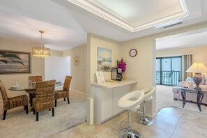 Un salon moderne comprenant un coin repas, un îlot de cuisine et un balcon avec vue.