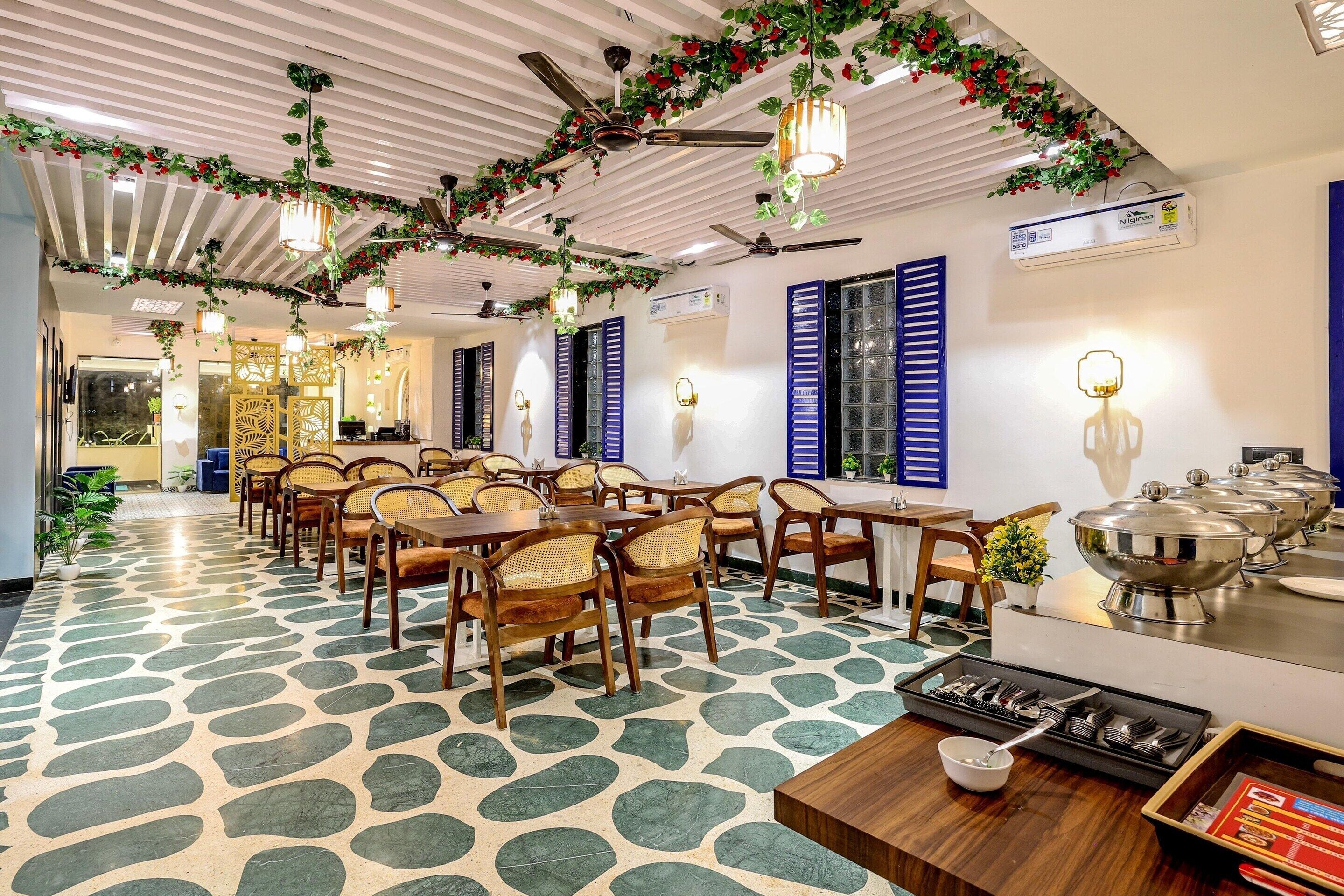 A dining area with ceiling fans, tables, chairs, and a buffet setup.