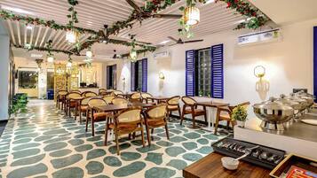 A dining area with ceiling fans, tables, chairs, and a buffet setup.