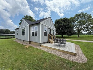 Une maison de plain-pied dotée d’une terrasse et d’un espace extérieur abrité.
