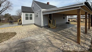 A single-story house with a covered porch, a deck, and a small outdoor seating area. - Pa’s House is an enjoyable, entirely remodeled, 2-bedroom farmhouse near Anna. (Anna)