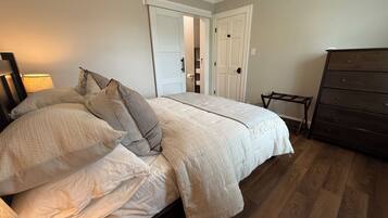 A bedroom with a bed, a dresser, and a door.