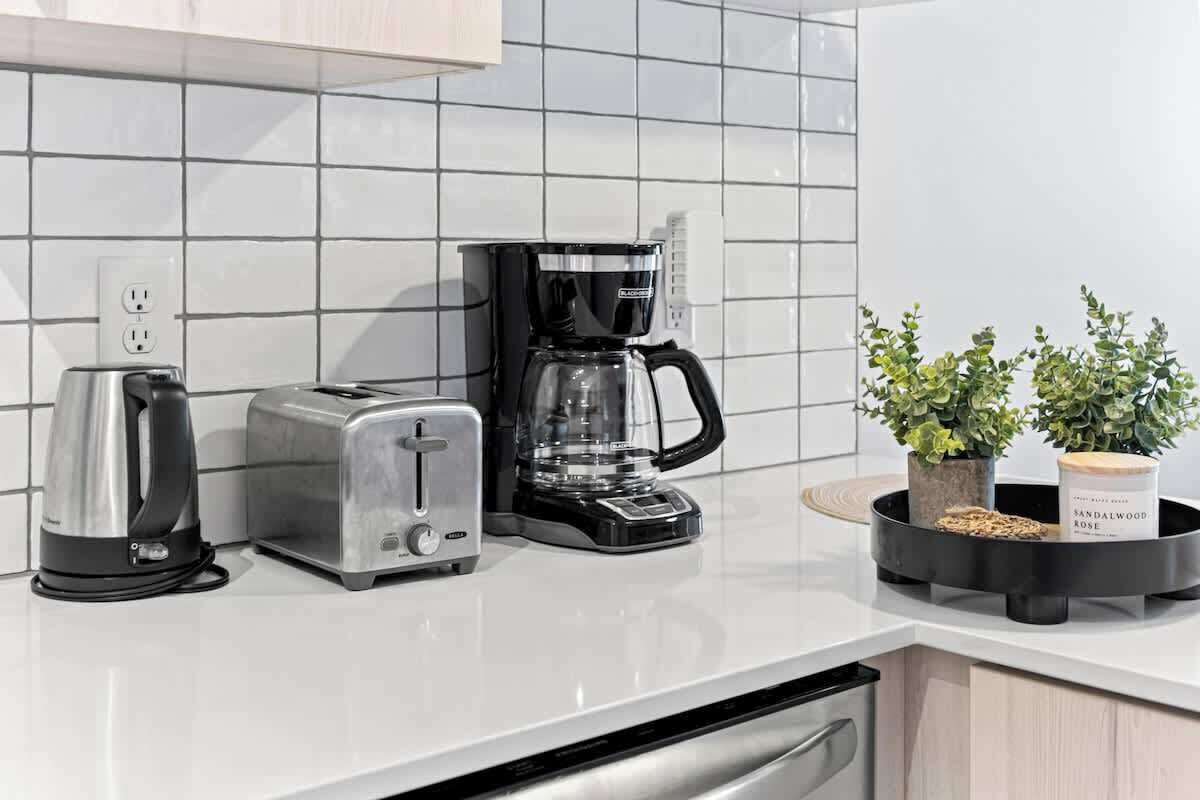 Eine Küche mit Kaffeemaschine, Toaster und einer Pflanze auf der Arbeitsfläche.