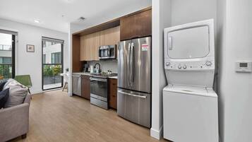A modern kitchen with stainless steel appliances, a built-in microwave, and a white oven.
