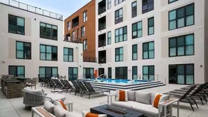 A rooftop pool area with lounge chairs and a fire pit. - Studio to Downtown w Rooftop (Cincinnati)
