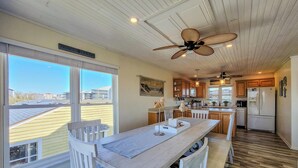 Una cocina con armarios de madera, una isla central y un ventilador de techo.