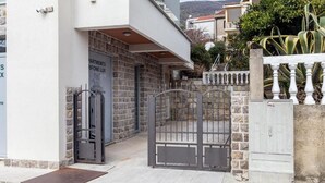 Ein Gebäude mit einer steinernen Fassade, einem Metallgitter und einem Schild mit der Aufschrift 'Apartments Riviera Lux'.