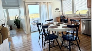 A spacious loft-style interior with a dining area, kitchen, and large windows offering views.