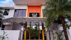 A hotel entrance with a thatched roof, a red carpet, and a sign reading 'HOTEL'. - Deluxe Vanam Resort (Vanur)