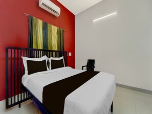 Ein Hotelzimmer mit einem Bett, einem Nachttisch und einer roten Wand.