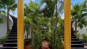 A staircase surrounded by lush greenery and palm trees, leading to an upper level. - Deluxe Vanam Resort (Vanur)