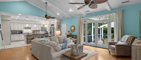 A spacious living area with a sofa, a coffee table, and a dining area with a kitchen in the background.
