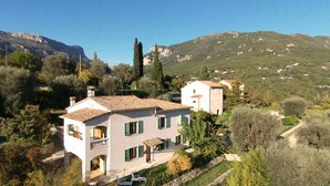 A two-story building with a tiled roof, surrounded by greenery and hills. - Pascaline, Holiday Cottage for 4 People (Le Bar-sur-Loup)