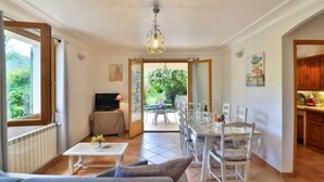A spacious living area with a sofa, TV, dining table, and chairs. - Pascaline, Holiday Cottage for 4 People (Le Bar-sur-Loup)