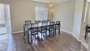 A dining area with a table and chairs, a ceiling fan, and a light fixture. - 4BR Montego Bay Villa Near Disney (Kissimmee)