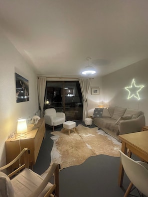 A cozy living room with a sofa, chairs, a table, a star-shaped light, and a cowhide rug. - Apartment in Serre Chevalier, near the slopes - 3 bedrooms - sleeps 6 (Le Monêtier-les-Bains)