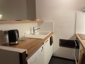 A kitchenette with a coffee maker, a glass mug, a sink, and a dishwasher. - Apartment in Serre Chevalier, near the slopes - 3 bedrooms - sleeps 6 (Le Monêtier-les-Bains)