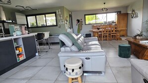 A modern kitchen with a dining area, a sofa, and a small stool. - Spacious, bright villa ideal for a stay in Mimizan with private pool (MIMIZAN)