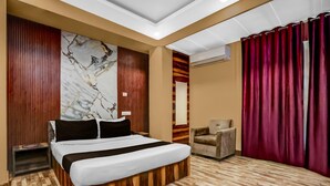 Une chambre d’hôtel avec un lit, une chaise, un plancher en bois, un mur en marbre et un rideau rouge.